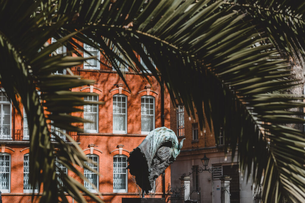 A palm tree and a sculpture in Mount Street Gardens Mayfair